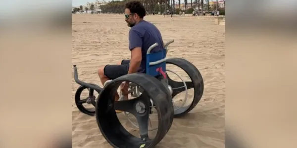 Cesar con su silla de ruedas en la playa