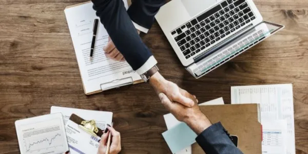 Manos de hombres sobre una mesa con ordenadores
