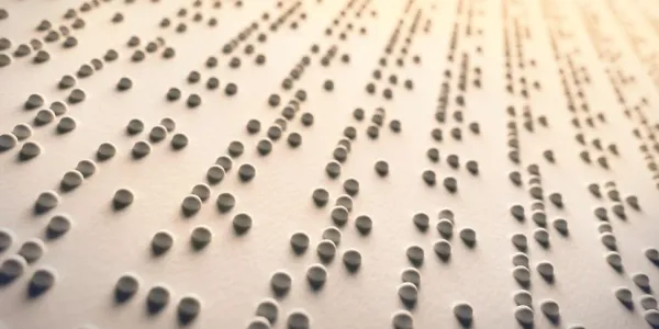 Primer plano de braille sobre papel para lectura accesible e inclusiva.