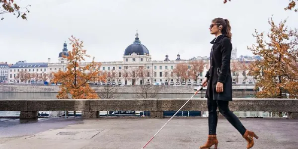 Una mujer con discapacidad visual paseando por una ciudad