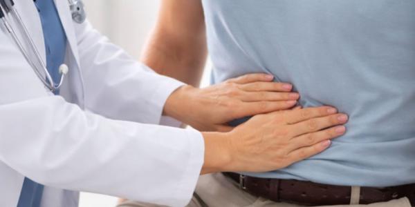 Médico palpando la tripa a un paciente