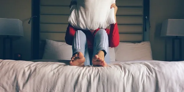 Niño tapándose la cara con una almohada