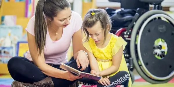 Una niña con discapacidad junto a su profesora.