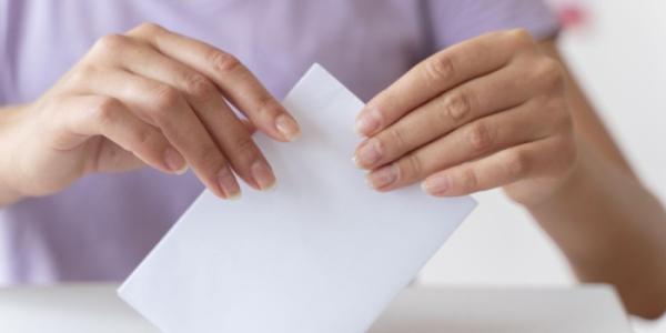 Una joven deposita su voto en una urna 