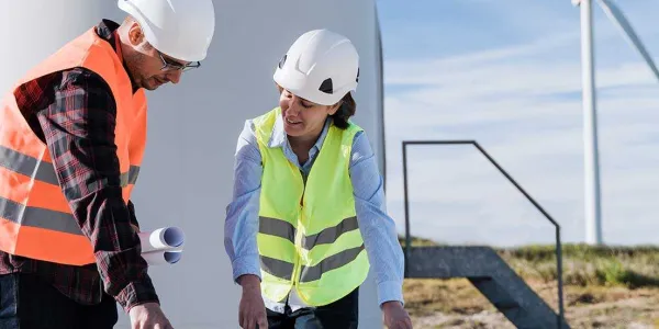 Dos personas trabajando en el sector de la energía eólica