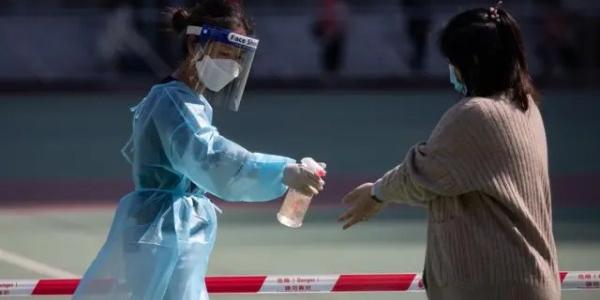 Una mujer aplica desinfectante a otra durante la pandemia de Covid.