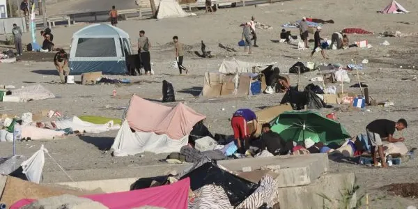 Varios migrantes permanecen este lunes acampados en la playa de El Trampolín de Ceuta