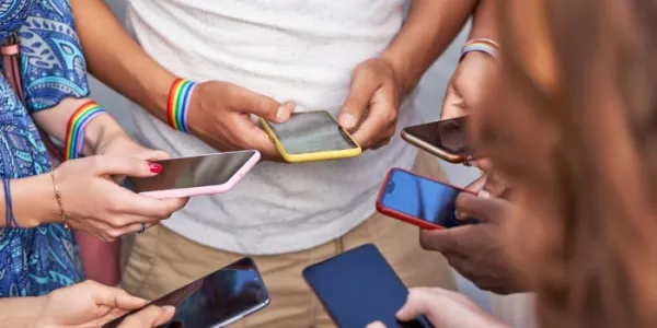 Grupo de personas que usan sus teléfonos móviles mientras están de pie juntas.