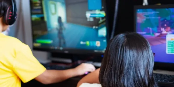 Dos niños ante pantallas con videojuegos
