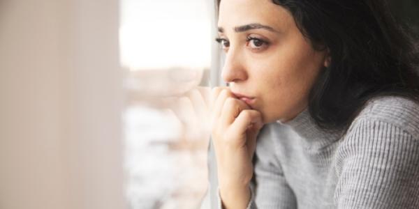 Una mujer con la mano en la cara expresando preocupación 