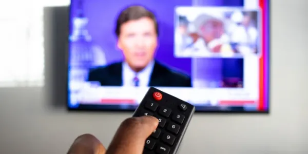 Persona pulsando el mando de la televisión