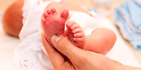 Una enfermera prepara el pie de un bebé para la prueba del talón