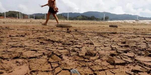 Una mujer caminando sobre un suelo afectado por la sequía en Filipinas