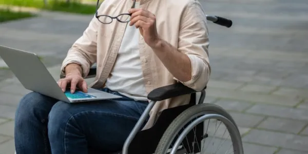 Un estudiante en silla de ruedas consulta su ordenador 