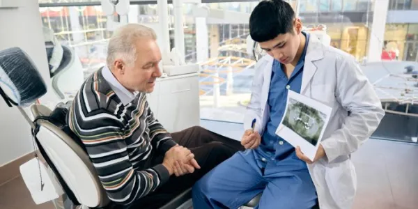 Un odontólogo enseña una radiografía a un paciente 