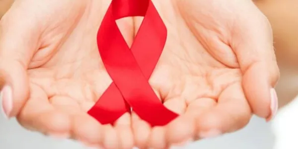 Dos manos sostienen un lazo rojo contra la hepatitis C