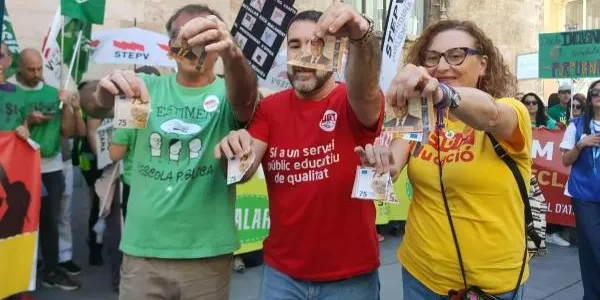 Marc Candela (STEPV), Kilian Cuerda (UGT) y Xelo Valls (CCOO) rompen un billete de 75 euros con la imagen del president Pérez Llorca a las puertas del Palau de la Generalitat