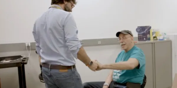Marco Capogrosso saluda a uno de los participantes en el ensayo (sentado)