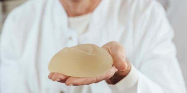 Doctor sujetando un implante mamario