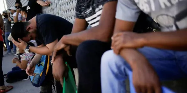 Migrantes del programa 'Permanecer en México' hacen fila fuera de las instalaciones del Instituto Nacional de Migración (INM) para renovar su permiso de permanencia legal en México, en espera de su audiencia de migración en Estados Unidos. Imagen en Ciudad Juárez, México, el 8 de julio de 2020. © Jose Luis González / Reuters