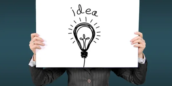 Persona sujetando un cartel en el que puede leerse "idea"