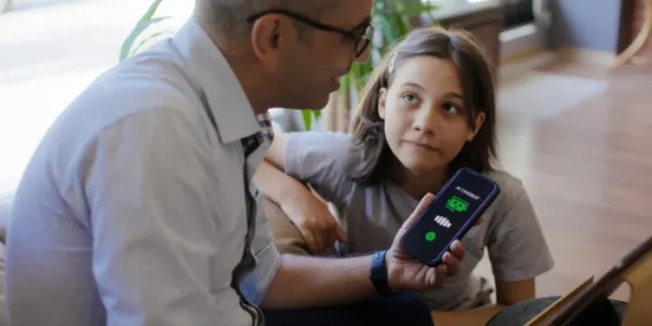 Padre e hija explorando un chatbot de IA. 