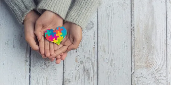Unas manos unidas, con un dibujo de un corazón