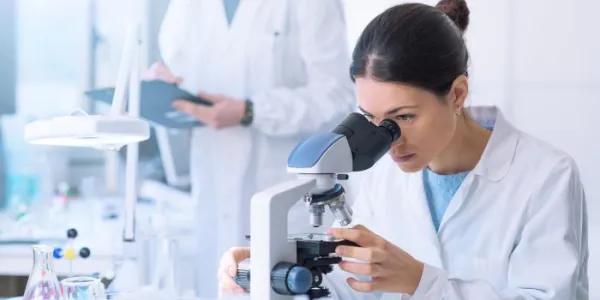 Una científica mirando por un microscopio 