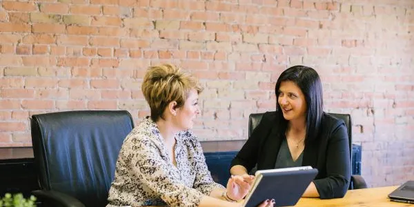 Dos señoras sentadas en la mesa de una empresa