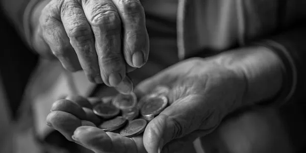 Manos de una persona mayor contando dinero