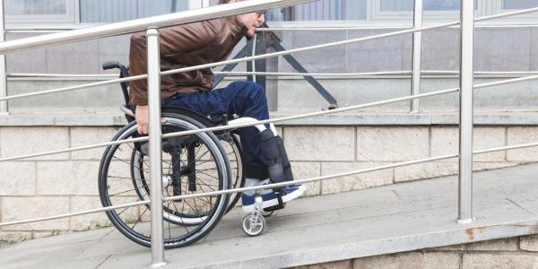 Una persona en silla de ruedas sube una rampa 