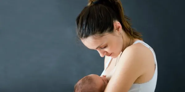 Una madre joven amamantando a su bebé recién nacido 