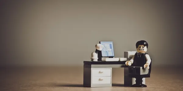 Muñeco lego sentado en una silla de oficina