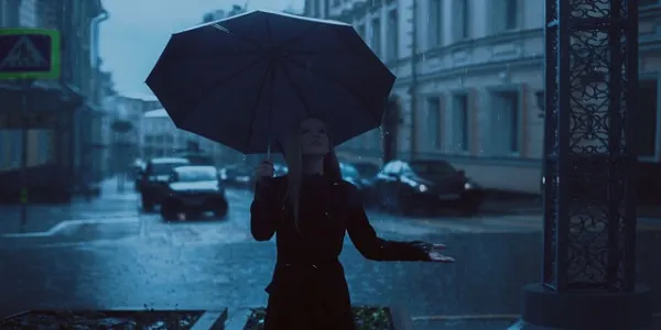 Chica con paraguas bajo la lluvia