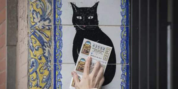 Una persona pasa un décimo de Lotería por azulejo de 'El gato negro' 