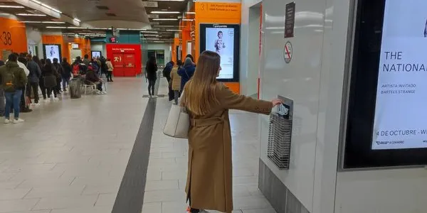 Una chica tira su mascarilla antes de subirse a su autobús.