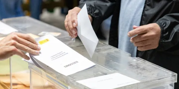Un hombre introduce su voto en una urna 