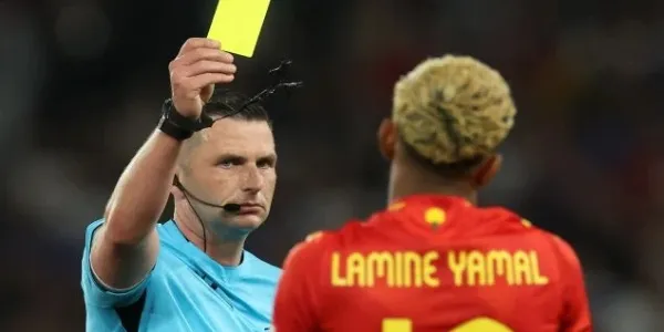 Michael Oliver muestra una amarilla a Lamine Yamal durante la pasada final de la Liga de Naciones