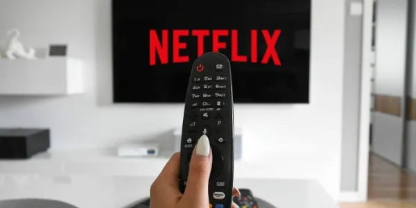 Persona con un mando apuntado a su tele viendo Netflix