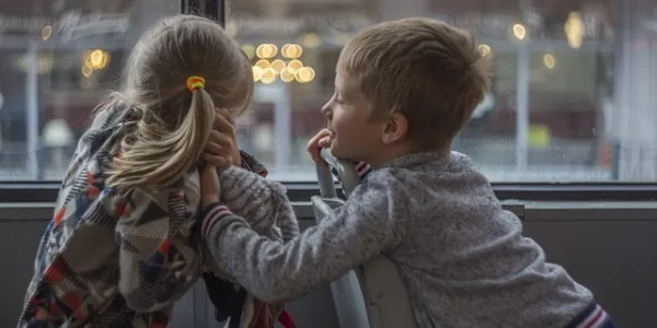 Dos niños mirando por una ventana
