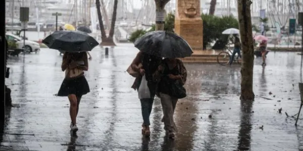 Transeúntes se protegen de las fuertes lluvias 