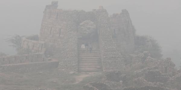 Visitantes en el fuerte de Tughlakabad en medio de una densa niebla tóxica en Nueva Delhi