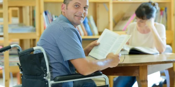 Un hombre con discapacidad, en la biblioteca de una universidad