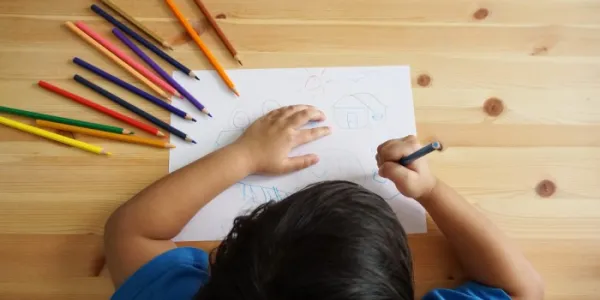 Un niño dibuja en su pupitre 