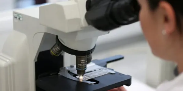Mujer mirando por el microscopio