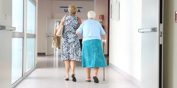 Dos personas mayores en el pasillo de un hospital