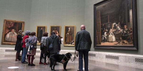 Una persona con discapacidad con su perro de asistencia en el Museo del Prado