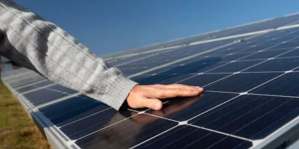 Placas solares y la mano de una persona