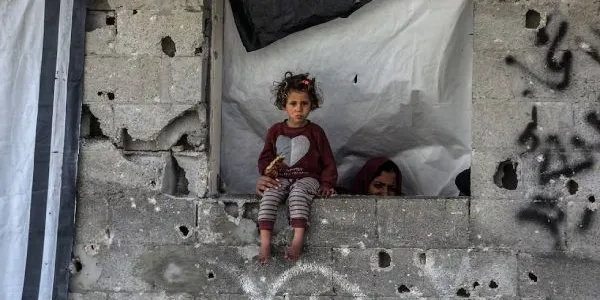 Se ve a una niña mientras palestinos examinan los escombros del edificio completamente derrumbado y buscan objetos utilizables tras un ataque aéreo llevado a cabo por el ejército israelí contra una casa perteneciente a la familia Abdulhadi en la ciudad de Khan Yunis, en el sur de la Franja de Gaza, el 6 de abril de 2025.