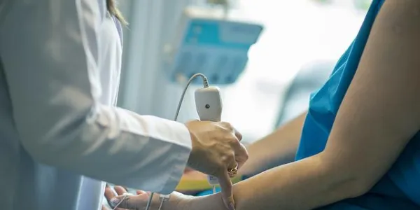 Una doctora tomándole la temperatura a un paciente 